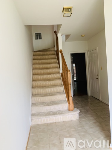 A staircase with wooden balusters and beige carpeted steps.