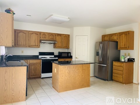 A kitchen with wooden cabinets and a black counter top.