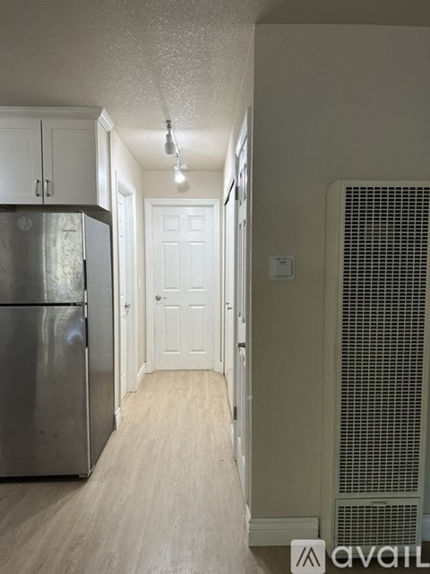 A kitchen with a stainless steel refrigerator and a white door.