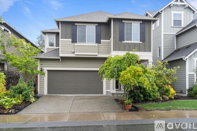 A house with a grey garage door is for sale.