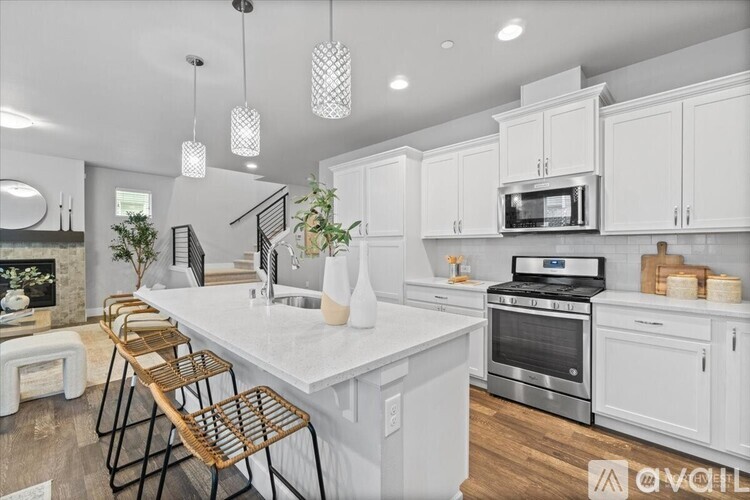 A modern kitchen with white cabinets and a marble countertop.