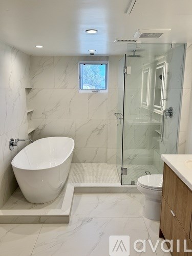 A bathroom with a white tub and a walk-in shower.