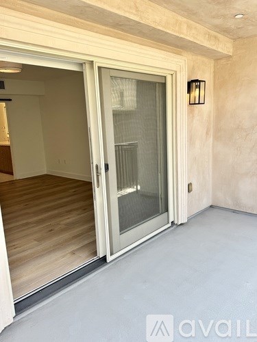 A room with a sliding glass door and a wooden floor.