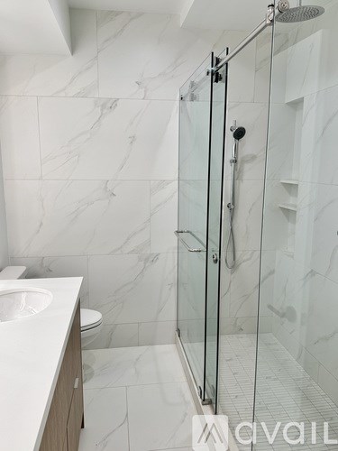A white marble bathroom with a walk in shower.