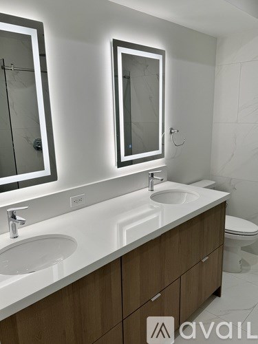 A bathroom with two sinks and a toilet.