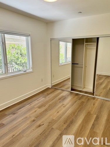 A room with wooden flooring and a sliding door.