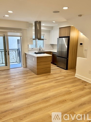 A modern kitchen with wooden floors and a large island.