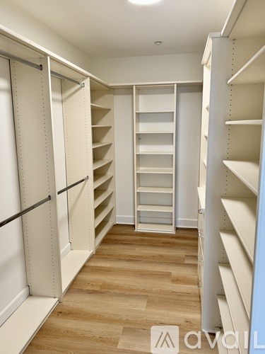 A white walk-in closet with shelves and drawers.