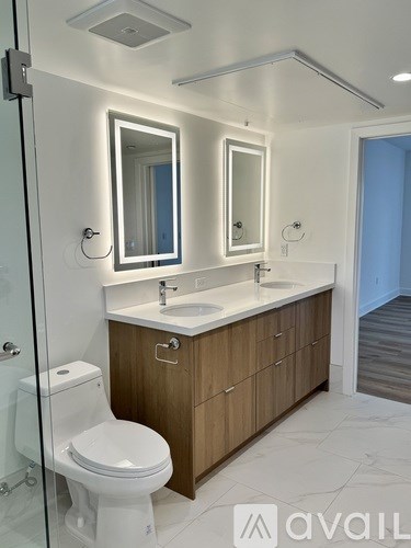A bathroom with a toilet, sink, and mirror.
