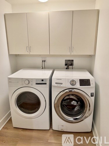 Two white front loading washing machines in a laundry room.