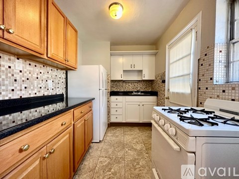 A kitchen with a white stove top oven and white fridge.