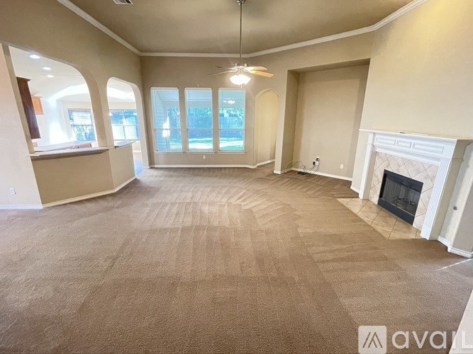 A spacious living room with a fireplace and large windows.