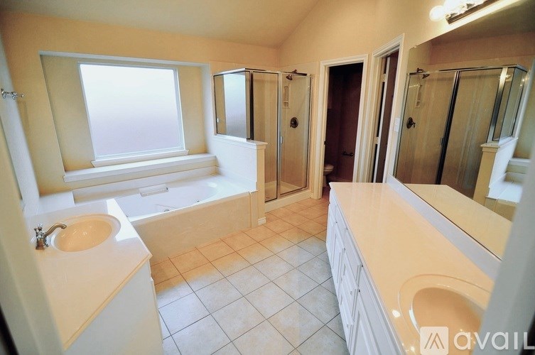 A bathroom with a tub, sink, and mirror.