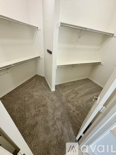 A small, empty room with carpeted floor and white walls.