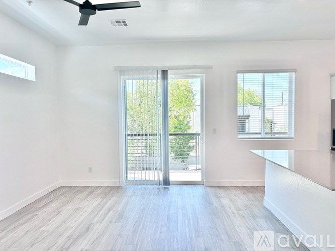 A spacious room with a sliding glass door leading to a balcony.