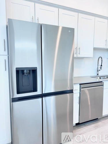 A stainless steel refrigerator with a black handle is in a kitchen.