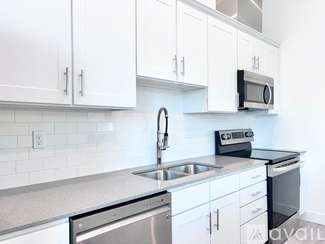 A kitchen with white cabinets and a stainless steel sink.