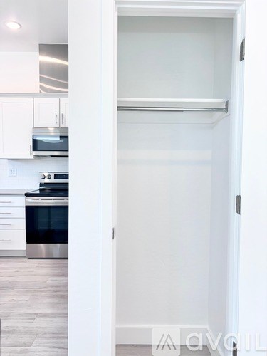 A white door is open to a kitchen.