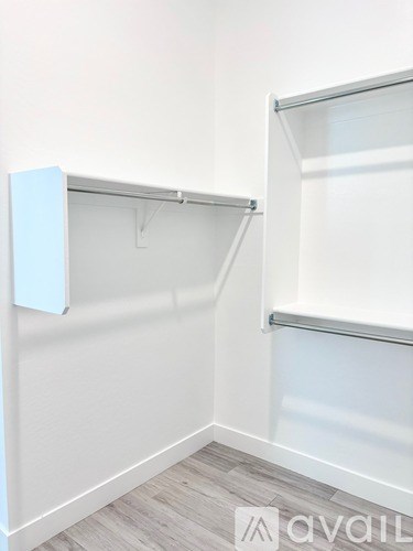 A white closet with a shelf and a hanger.