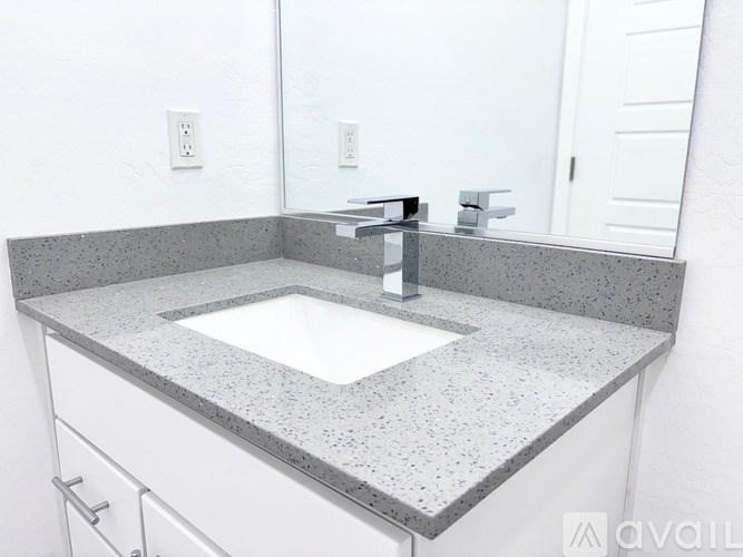A bathroom with a granite countertop and a white sink.