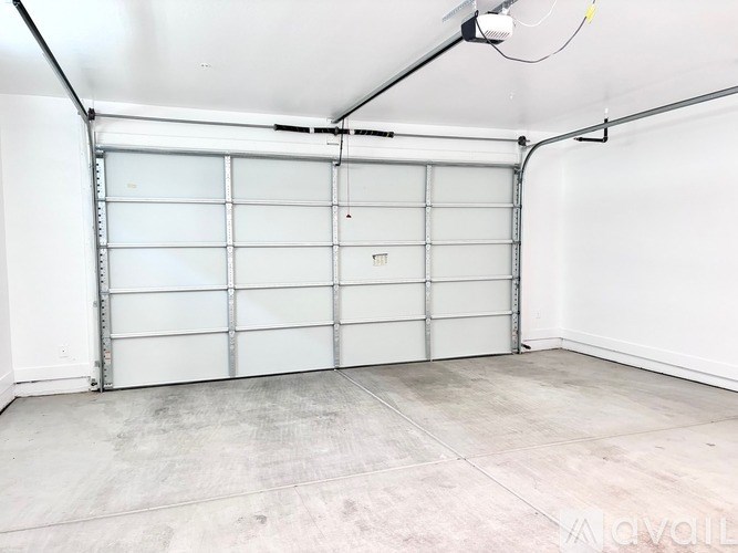 A large white garage door is closed and the garage is empty.