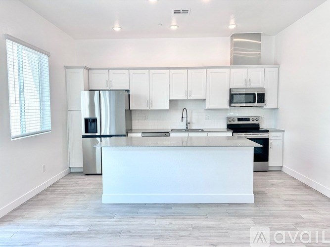 A modern kitchen with white cabinets and stainless steel appliances.
