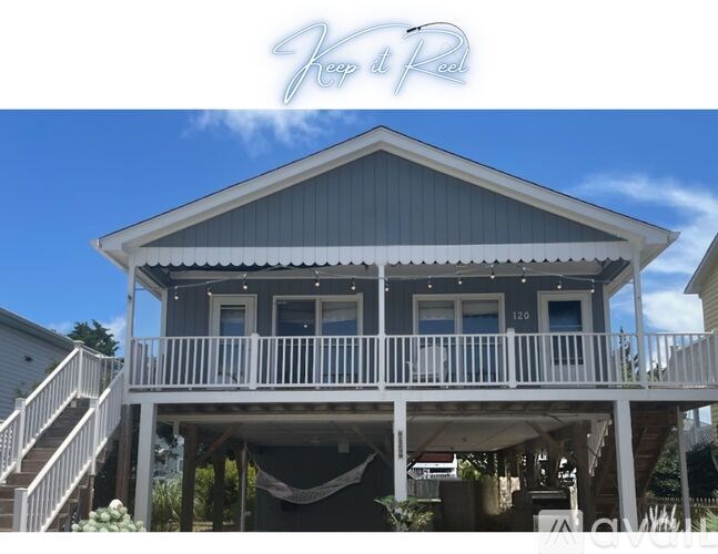A house with a blue roof and white railings.