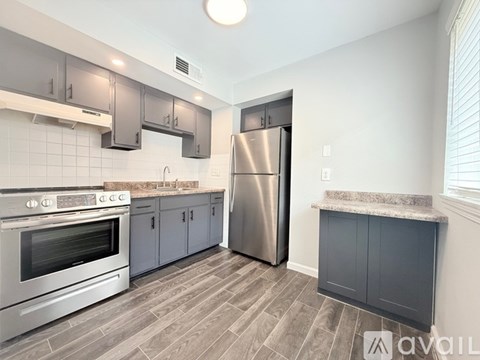 A kitchen with a stainless steel refrigerator and oven, and a marble countertop.