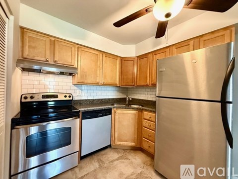 A kitchen with wooden cabinets and a stainless steel refrigerator.
