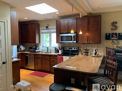 A kitchen with wooden cabinets and a granite countertop.