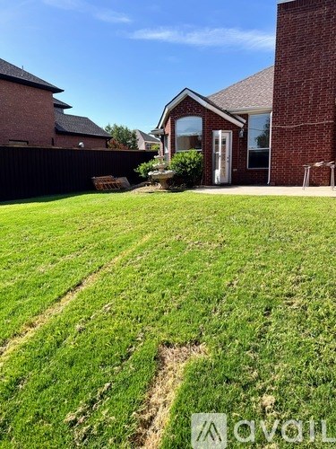 A grassy yard with a house in the background.