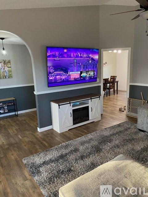 A living room with a television on a stand and a chair.