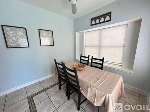 A dining room with a table and chairs.