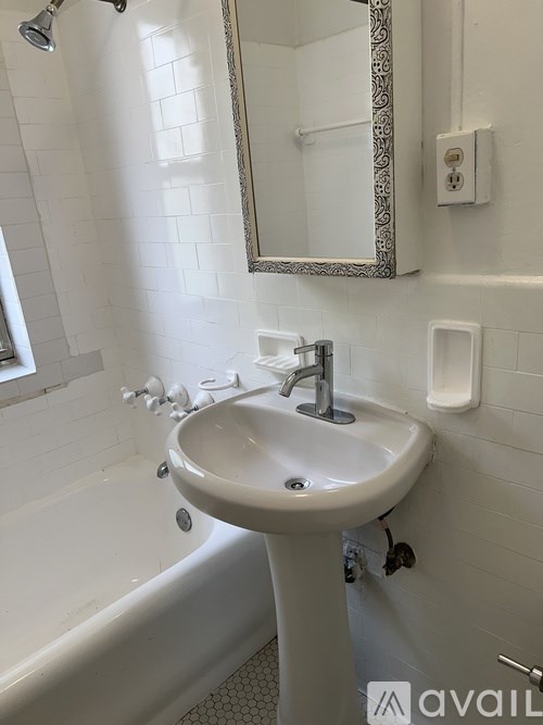A white sink in a bathroom with a mirror above it.