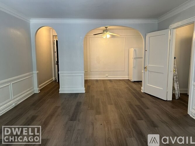A room with wooden flooring and white walls.