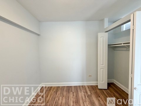 A kitchen with a white refrigerator and white cabinets.