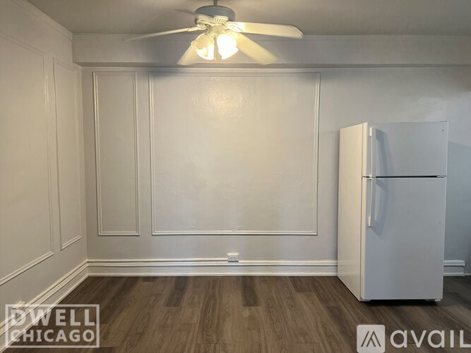 A room with a white ceiling fan and a white refrigerator.