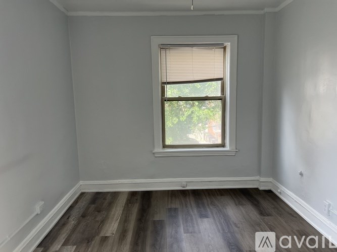 A room with a window and wooden flooring.