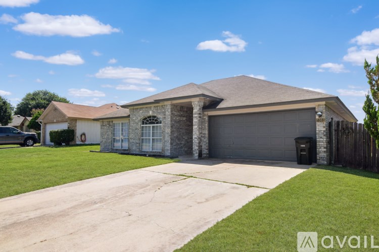 A house with a grey garage door and a black car parked in front.