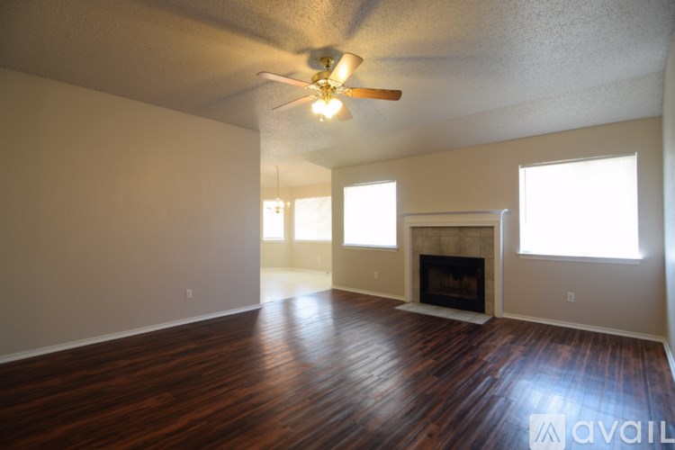 A room with a ceiling fan and a window letting in sunlight.