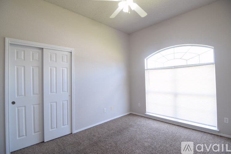 A room with a ceiling fan and two doors.