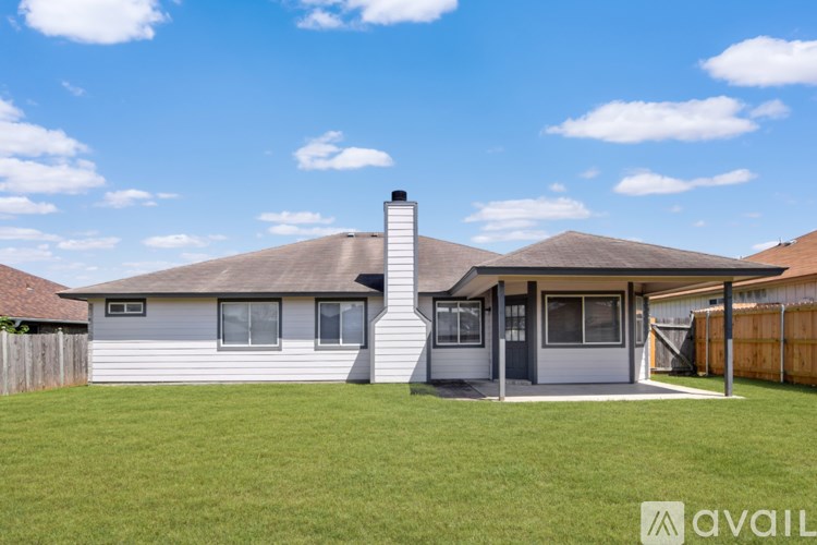 A house with a grey roof and a white chimney is for sale.