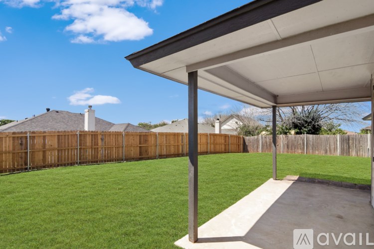 A backyard with a wooden fence and a clear blue sky.