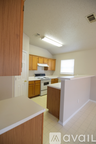 A kitchen with wooden cabinets and a white counter.