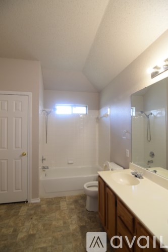 A bathroom with a tub, toilet, and sink.