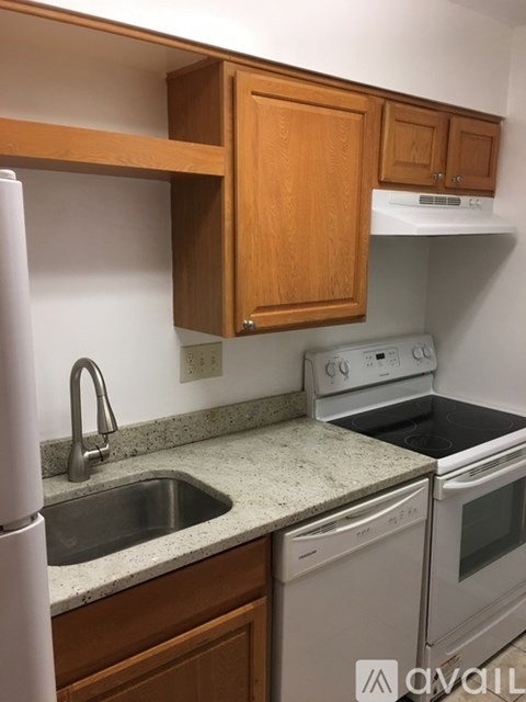 A kitchen with a white fridge, a white oven and a white sink.
