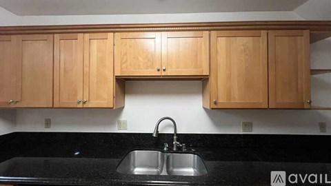 A kitchen with wooden cabinets and a black countertop.