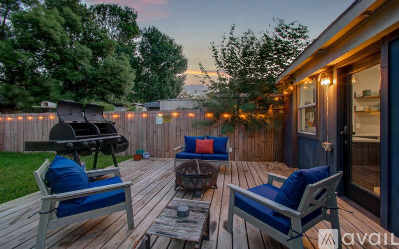 A wooden deck with two chairs and a table is set up for relaxation.