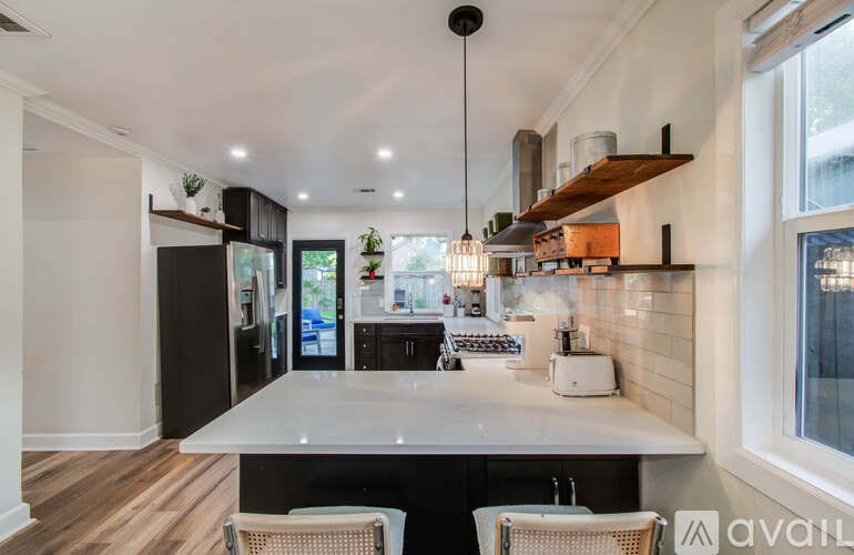 A modern kitchen with a large island and a dining area.
