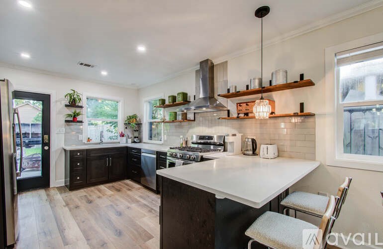 A kitchen with a white countertop and wooden floors.